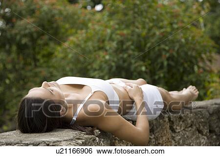Portrait of an Hispanic woman laying on a wall relaxing. View Large Photo Image Stock Photograph - Portrait of an Hispanic woman laying on a wall relaxing.. Fotosearch