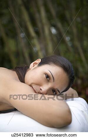 Smiling Hispanic woman on a massage table in a tropical setting View Large Photo Image Stock Image - Smiling Hispanic woman on a massage table in a tropical setting. Fotosearch