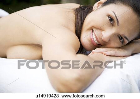 Smiling Hispanic woman on a massage table in a tropical setting View Large Photo Image Stock Photo - Smiling Hispanic woman on a massage table in a tropical setting. Fotosearch
