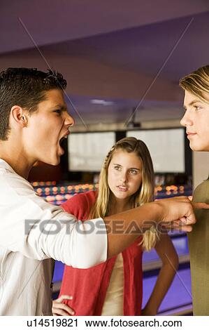 Stock Image - Argument between teenage boys in a bowling alley. Fotosearch