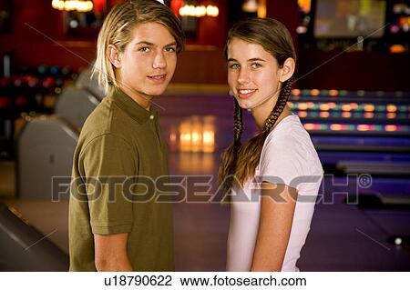 Teenage boy and girl in a bowling alley View Large Photo Image Stock Image - Teenage boy and girl in a bowling alley. Fotosearch