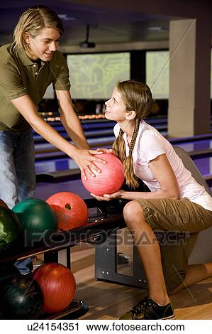 Teenage boy and girl in a bowling alley, flirting View Large Photo Image Stock Image - Teenage boy and girl in a bowling alley, flirting. Fotosearch