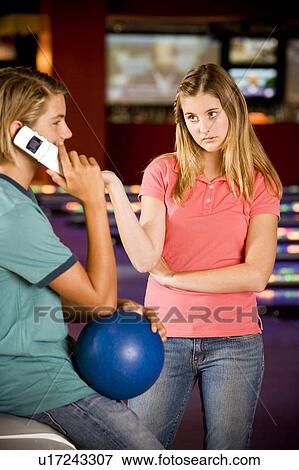 Teenage boy and girl in a bowling alley, boy talking on mobile phone View Large Photo Image Stock Photo - Teenage boy and girl in a bowling alley, boy talking on mobile phone. Fotosearch