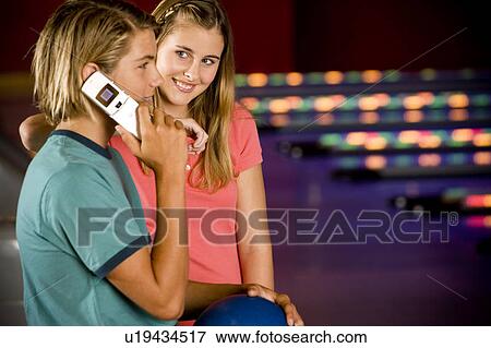 Teenage boy and girl in a bowling alley, boy talking on mobile phone View Large Photo Image Stock Photo - Teenage boy and girl in a bowling alley, boy talking on mobile phone. Fotosearch