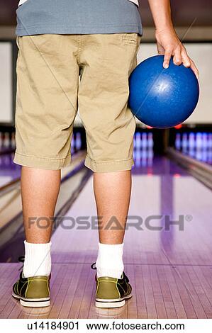 Teenage boy in a bowling alley, holding a blue bowling ball View Large Photo Image Stock Image - Teenage boy in a bowling alley, holding a blue bowling ball. Fotosearch
