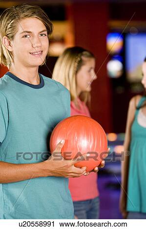 Teenage boy in a bowling alley, two girls in the background View Large Photo Image Stock Image - Teenage boy in a bowling alley, two girls in the background. Fotosearch