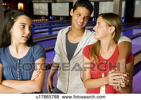 Stock Photo - Teenage couple in a bowling alley, watched by jealous rival. Fotosearch