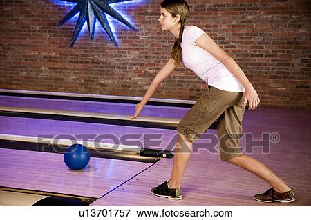 Teenage girl in a bowling alley, rolling the ball View Large Photo Image Stock Photo - Teenage girl in a bowling alley, rolling the ball. Fotosearch