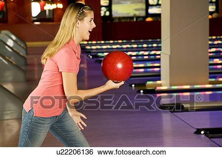 Stock Photograph - Teenage girl in bowling alley, about to play. Fotosearch