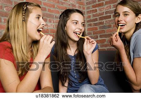 Three teenage girls eating chips View Large Photo Image Stock Image - Three teenage girls eating chips. Fotosearch