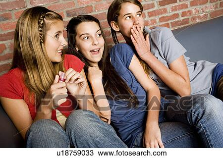 Three teenage girls giggling at something out of shot View Large Photo Image Stock Image - Three teenage girls giggling at something out of shot. Fotosearch