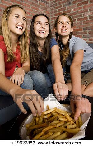 Three teenage girls sharing a plate of chips View Large Photo Image Stock Photo - Three teenage girls sharing a plate of chips. Fotosearch