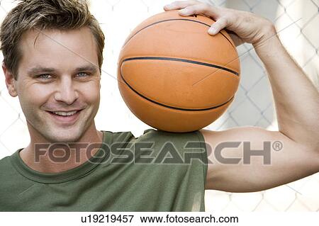Man in a green vest holding a basketball. View Large Photo Image Stock Photo - Man in a green vest holding a basketball.. Fotosearch