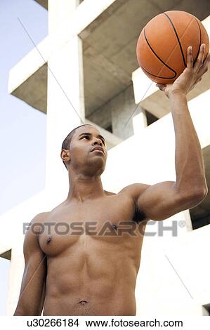 Portrait of a young African American man holding up a basketball.  View Large Photo Image Picture - Portrait of a young African American man holding up a basketball. . Fotosearch