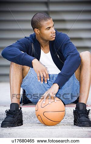 Portrait of a young African American man sitting with a basketball. View Large Photo Image Stock Photography - Portrait of a young African American man sitting with a basketball. . Fotosearch