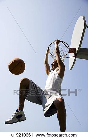 Portrait of young African jumping and hanging from a basketball ring View Large Photo Image Stock Image - Portrait of young African jumping and hanging from a basketball ring. Fotosearch
