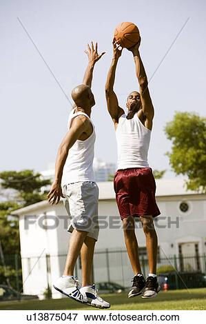 Two African American man jumping for a basketball View Large Photo Image Stock Photo - Two African American man jumping for a basketball. Fotosearch