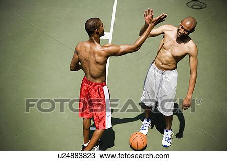 Two men giving high five on an outdoor basketball court  View Large Photo Image Stock Image - Two men giving high five on an outdoor basketball court . Fotosearch