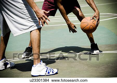 Two men playing on an outdoor basketball court View Large Photo Image Picture - Two men playing on an outdoor basketball court. Fotosearch