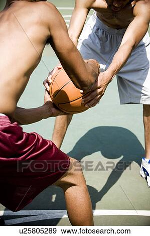 Stock Photo - Two men playing on an outdoor basketball court. Fotosearch