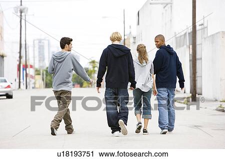 Stock Image - Group of teenagers running down an urban street . Fotosearch