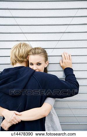 Portrait of a young couple leaning against a metallic wall View Large Photo Image Stock Image - Portrait of a young couple leaning against a metallic wall . Fotosearch