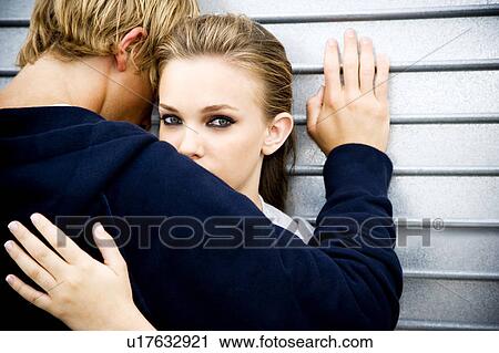 Portrait of a young couple leaning against a metallic wall View Large Photo Image Stock Image - Portrait of a young couple leaning against a metallic wall . Fotosearch