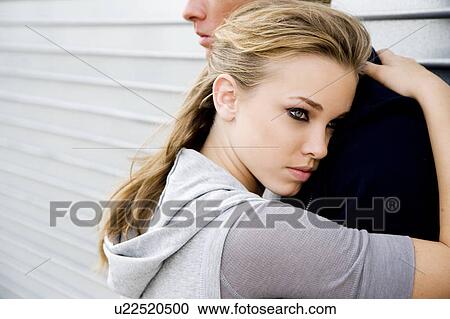 Portrait of a young couple leaning against a metallic wall View Large Photo Image Stock Image - Portrait of a young couple leaning against a metallic wall . Fotosearch