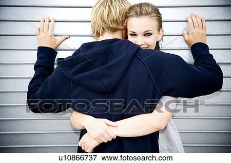 Portrait of a young couple leaning against a metallic wall View Large Photo Image Stock Photo - Portrait of a young couple leaning against a metallic wall . Fotosearch
