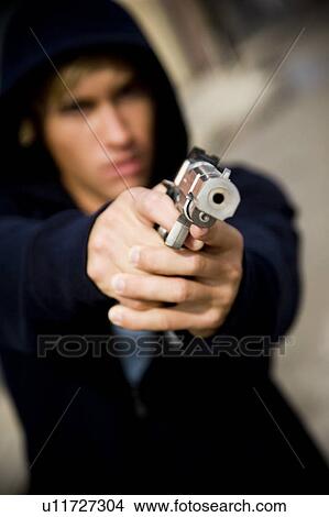 Picture - Portrait of a young man holding a gun . Fotosearch