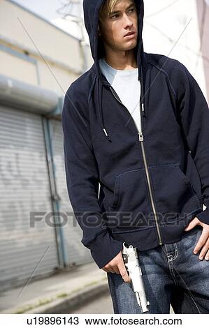 Stock Image - Portrait of a young man holding a gun . Fotosearch