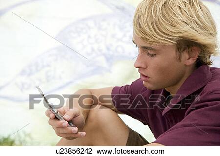 Portrait of a young man on a mobile in front of a graffiti covered wall View Large Photo Image Stock Image - Portrait of a young man on a mobile in front of a graffiti covered wall. Fotosearch