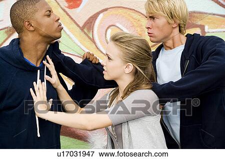 Two men fighting over a girl in front of a graffiti covered wall View Large Photo Image Stock Photo - Two men fighting over a girl in front of a graffiti covered wall . Fotosearch