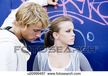 Stock Photo - Young teenage couple in front of a graffiti covered wall. Fotosearch