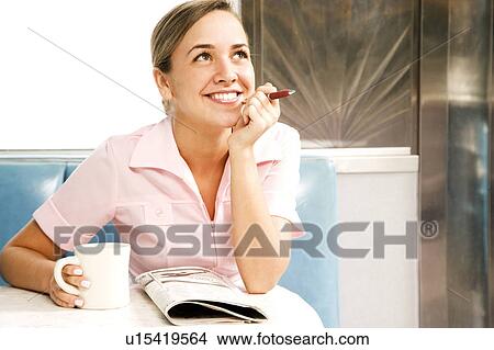 Picture - Diner waitress looking at the classified section of a newspaper . Fotosearch