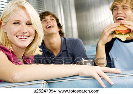 Portrait of a smiling teenage girl with her friends in a diner View Large Photo Image Picture - Portrait of a smiling teenage girl with her friends in a diner . Fotosearch