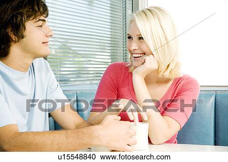 Stock Image - Portrait of a teenage couple flirting in a diner. Fotosearch