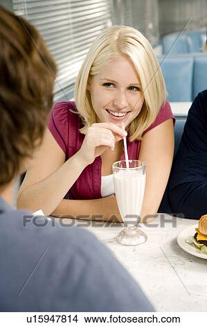 Picture - Portrait of a teenage girl drinking a milkshake . Fotosearch