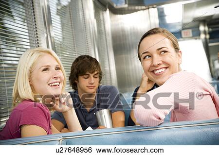 Stock Photograph - Portrait of smiling teenage girls with her friends in a diner . Fotosearch