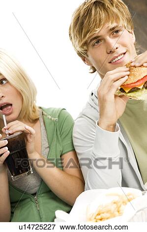 Teenage boy eating a large hamburger in a diner View Large Photo Image Stock Photo - Teenage boy eating a large hamburger in a diner . Fotosearch