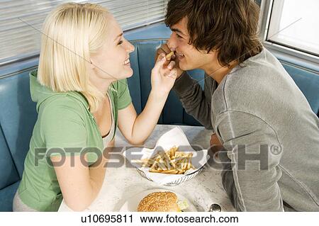 Stock Image - Teenage couple in a diner. Fotosearch