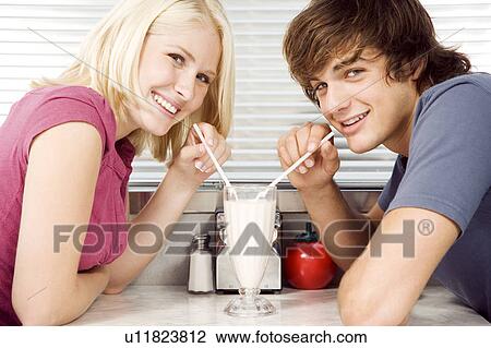 Teenage couple sharing a milkshake View Large Photo Image Stock Image - Teenage couple sharing a milkshake . Fotosearch