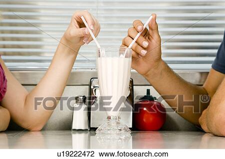 Teenage couple sharing a milkshake View Large Photo Image Stock Image - Teenage couple sharing a milkshake . Fotosearch