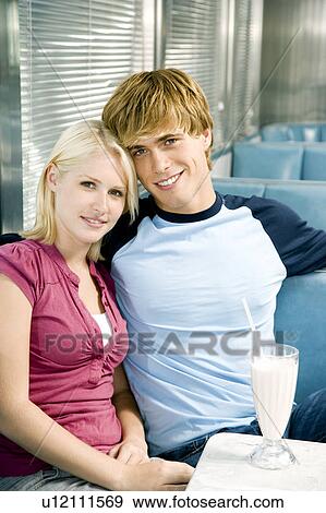 Teenage couple sharing a milkshake sitting in a diner View Large Photo Image Stock Photo - Teenage couple sharing a milkshake sitting in a diner . Fotosearch