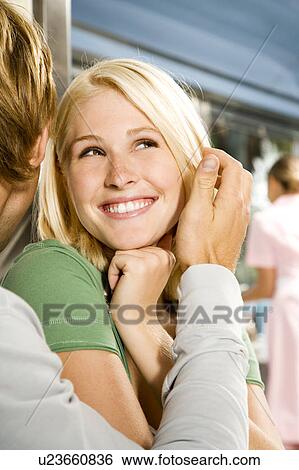 Stock Photograph - Young couple embracing, sitting in a diner . Fotosearch