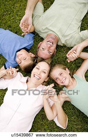 Stock Photo - family lying on ground holding hands in a star shape. Fotosearch