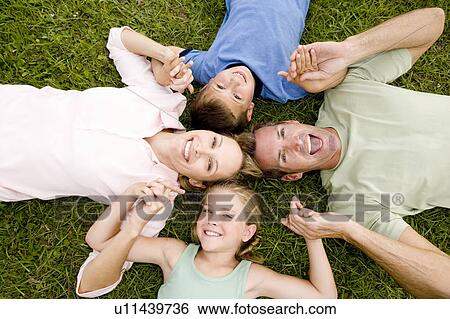family lying on ground holding hands in a star shape View Large Photo Image Stock Photograph - family lying on ground holding hands in a star shape. Fotosearch