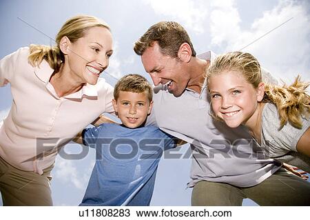 Stock Image - family of four hugging each other. Fotosearch