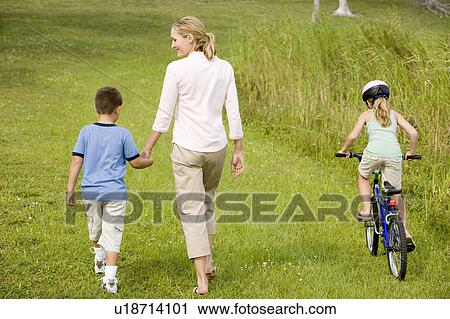 Stock Image - family walking and cycling in the countryside. Fotosearch