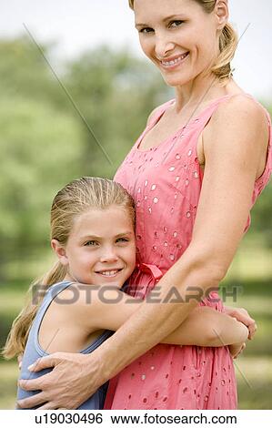Stock Photograph - girl hugging mother around waist. Fotosearch